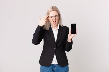 sarışın güzel bir kadın mutsuz ve stresli görünüyor, intihar jesti silah işareti yapıyor ve elinde bir cep telefonu var