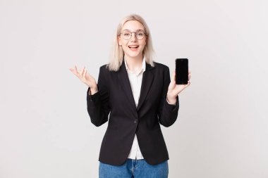 Sarışın, güzel bir kadın mutlu, şaşırmış bir şekilde çözümü ya da fikri fark ediyor ve elinde bir cep telefonu tutuyor.