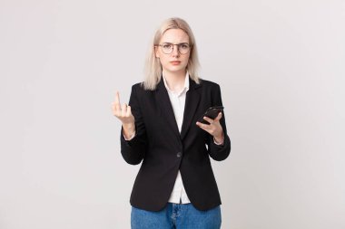 sarışın güzel bir kadın kızgın, sinirli, asi ve agresif ve elinde bir cep telefonu tutuyor.