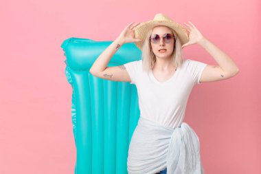 Sarışın, güzel bir kadın gergin, endişeli ya da korkmuş, elleri başının üstünde. yaz konsepti