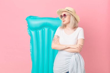 Sarışın, güzel bir kadın omuz silkiyor, kafası karışık ve kararsız. yaz konsepti