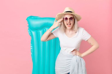 Sarışın, güzel, mutsuz ve stresli bir kadın. İntihar işareti yapıyor. yaz konsepti