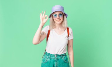 Sarışın, güzel bir kadın kendini mutlu hissediyor, iyi bir jestle onaylıyor. yaz konsepti