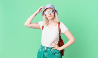 Kafası karışmış, kafası karışmış, kaşınan güzel sarışın bir kadın. yaz konsepti