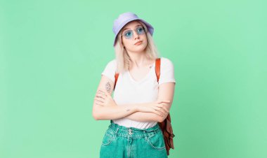 Sarışın, güzel bir kadın omuz silkiyor, kafası karışık ve kararsız. yaz konsepti