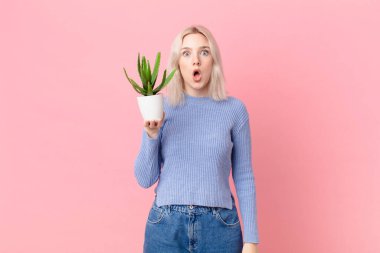 blond woman holding a cactus