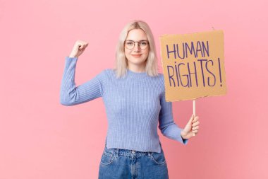 blond woman protesting with a cardboard banner