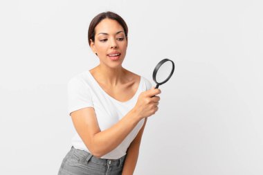 Genç İspanyol kadın elinde büyüteç tutuyor.