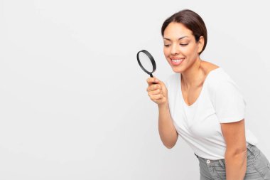 Genç İspanyol kadın elinde büyüteç tutuyor.