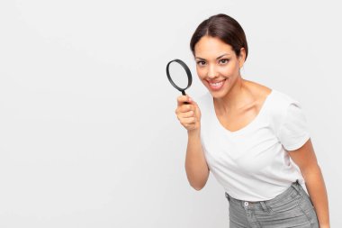 Genç İspanyol kadın elinde büyüteç tutuyor.