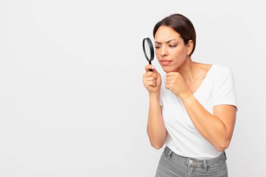 Genç İspanyol kadın elinde büyüteç tutuyor.