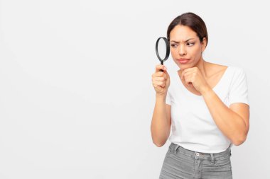 Genç İspanyol kadın elinde büyüteç tutuyor.