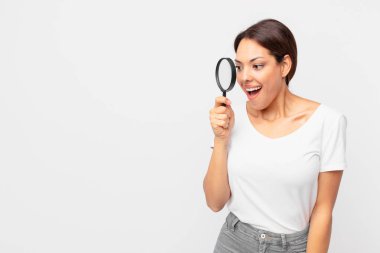 Genç İspanyol kadın elinde büyüteç tutuyor.