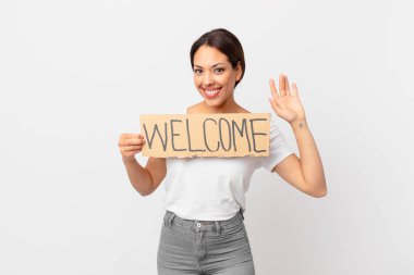 Hoş geldin bayrağı tutan genç İspanyol kadın.