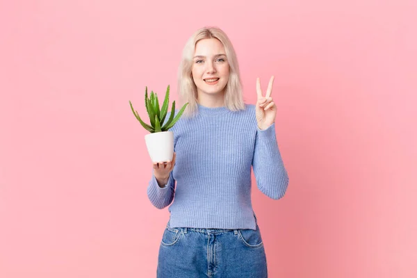 Blond Woman Holding Cactus — Zdjęcie stockowe
