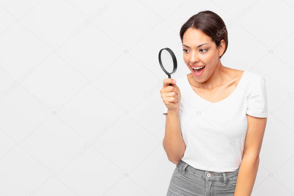young hispanic woman holding a magnifying glass