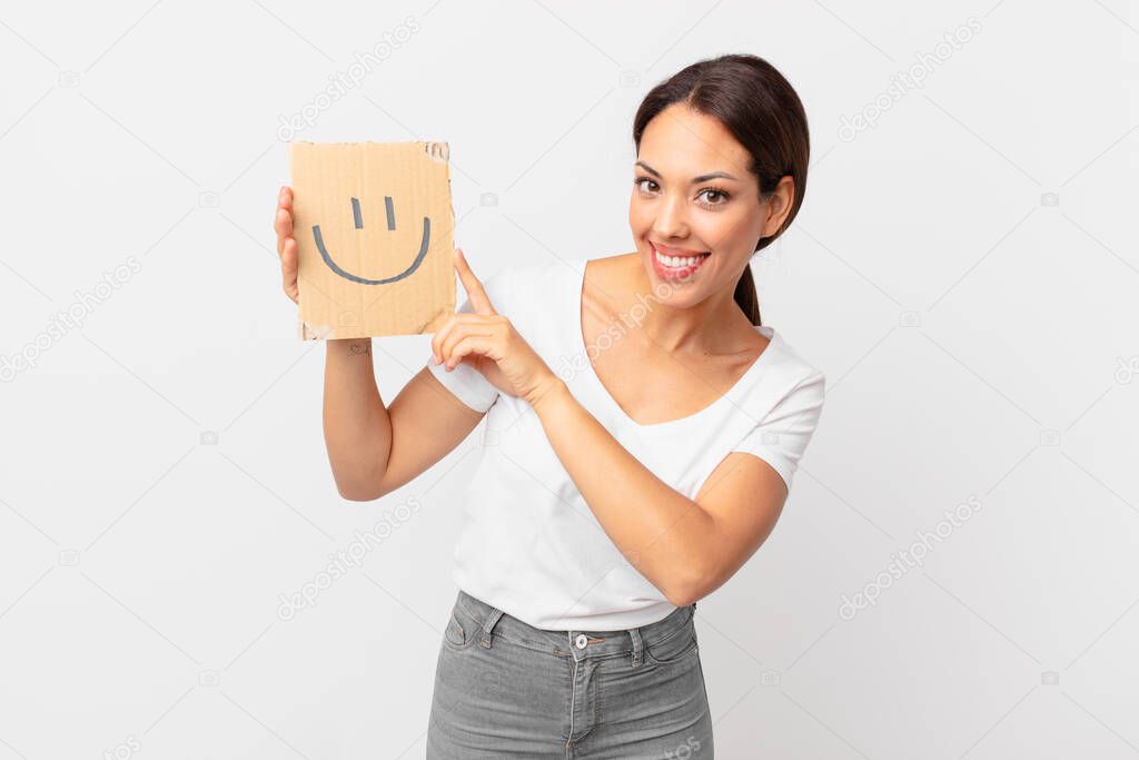 young hispanic woman holding a smiley face banner