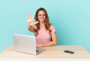 Güzel bayan gülümsüyor ve arkadaş canlısı görünüyor, beş numarayı gösteriyor. telework konsepti