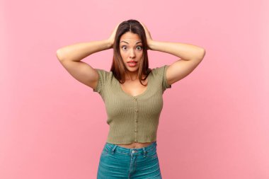 Genç İspanyol kadın stresli, endişeli ya da korkmuş hissediyor, elleri başının üstünde.