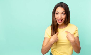 Genç İspanyol kadın kendini mutlu hissediyor ve heyecanla kendini işaret ediyor.