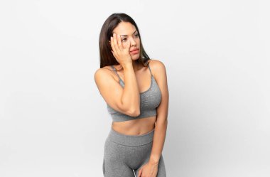 Genç İspanyol bir kadın bıkkın, hayal kırıklığına uğramış ve yorucu bir günün ardından uykulu hissediyor. fitness konsepti