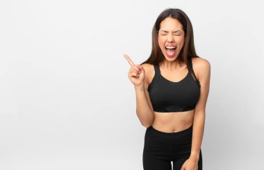 Genç İspanyol kadın agresif bir şekilde bağırıyor, çok kızgın görünüyor. fitness konsepti