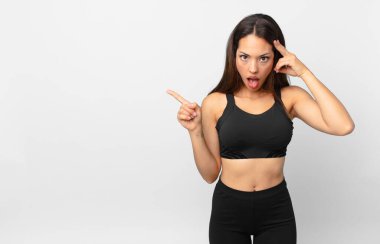 Genç İspanyol kadın şaşırmış görünüyor, yeni bir düşünce, fikir ya da konsept keşfediyor. fitness konsepti