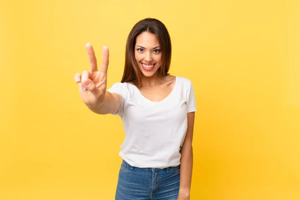 若いヒスパニック系の女性は笑顔で幸せそうに見える勝利や平和をジェスチャーで — ストック写真