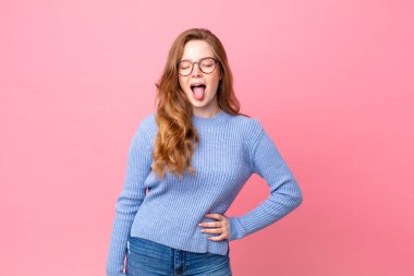 Güzel kızıl saçlı, neşeli ve asi tavırlı, şaka yapan ve dilini dışarı çıkaran bir kadın.