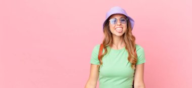 Neşeli ve asi tavırlı, şaka yapan ve dilini dışarı çıkaran güzel bir kadın. yaz konsepti