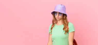 Güzel bir kadın üzgün, üzgün ya da kızgın hisseder ve bir tarafa bakar. yaz konsepti