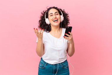 Güzel Arap kadın kendini mutlu hissediyor. Çözümü ya da fikri kulaklıkla ya da akıllı telefonla fark edince şaşırıyor.