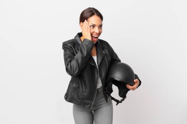 Genç İspanyol kadın mutlu, heyecanlı ve şaşırmış hissediyor. Motosiklet sürücüsü konsepti