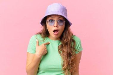 Şok olmuş ve ağzı açık, kendini gösteren genç ve güzel bir kadın. yaz konsepti