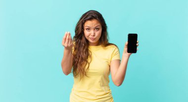 Genç ve güzel bir kadın kapiş ya da para hareketi yapıyor. Sana ödemeni söylüyor ve elinde akıllı bir telefon tutuyor.