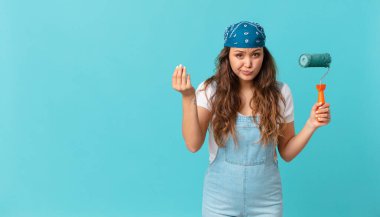Genç ve güzel bir kadın kapiş ya da para hareketi yapıyor, sana para ödemeni ve duvar boyamanı söylüyor.