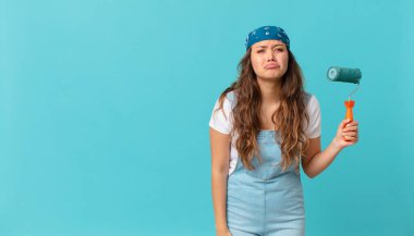 Genç, güzel bir kadın üzgün ve sızlanıyor. Mutsuz bir bakışla, ağlıyor ve duvar boyuyor.