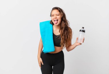 Neşeli ve asi tavırları olan genç ve güzel bir kadın, şaka yapıyor ve dilini dışarı çıkarıyor. fitness konsepti