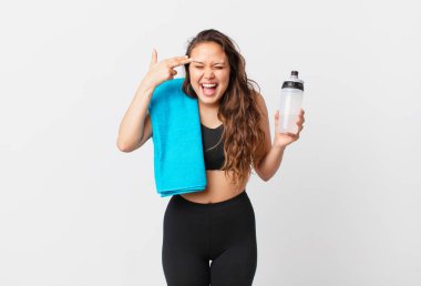 Genç ve güzel bir kadın mutsuz ve stresli görünüyor, intihar jesti silah işareti yapıyor. fitness konsepti