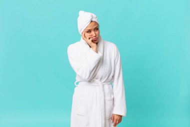 Genç ve güzel bir kadın yorgun düştükten sonra sıkılmış, hayal kırıklığına uğramış ve uykulu hissediyor ve duş üstüne banyo bornozu giyiyor.