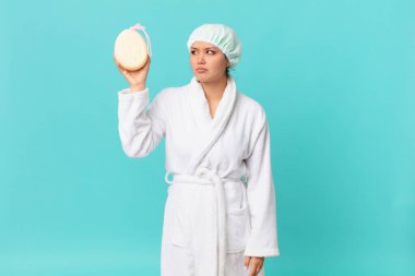 Genç, güzel bir kadın üzgün, üzgün ya da kızgın ve duştan sonra banyo cübbesi giyiyor.