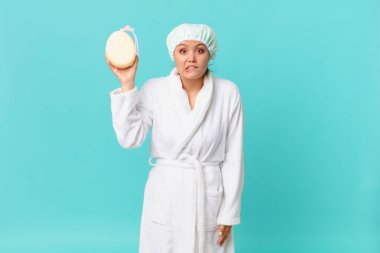 Kafası karışmış ve duştan sonra banyo cübbesi giyen genç ve güzel bir kadın.