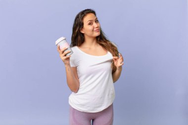 Genç ve güzel bir kadın kibirli, başarılı, pozitif ve gururlu görünüyor ve elinde kahve tutuyor.