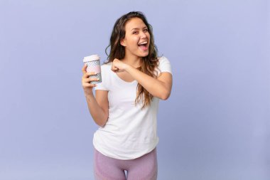 Genç ve güzel bir kadın kendini mutlu hisseder ve meydan okumayla yüzleşir ya da kutlama yapar ve kahve içer.