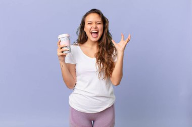 Elleri havada ve elinde kahve tutarak çığlık atan genç ve güzel bir kadın.