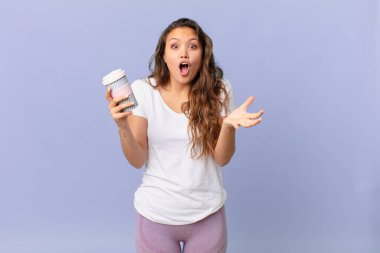 Genç, güzel bir kadın şok olmuş, şaşırmış ve elinde kahve tutuyor.