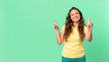 Genç ve güzel bir bayan gülümsüyor ve arkadaş canlısı görünüyor, bir numarayı gösteriyor ve fotokopi alanını işaret ediyor.