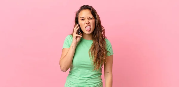 Joven Bonita Mujer Sintiéndose Disgustada Irritada Lengua Fuera Sosteniendo Teléfono — Foto de Stock