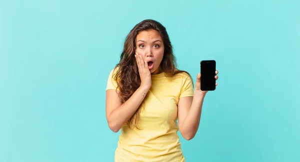 Młoda Ładna Kobieta Czuje Się Zszokowana Przerażona Trzyma Smartfon — Zdjęcie stockowe