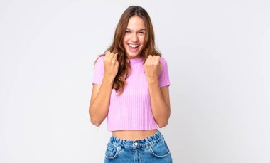 Genç ve güzel bir kadın şokta, gülüyor ve başarıyı kutluyor.